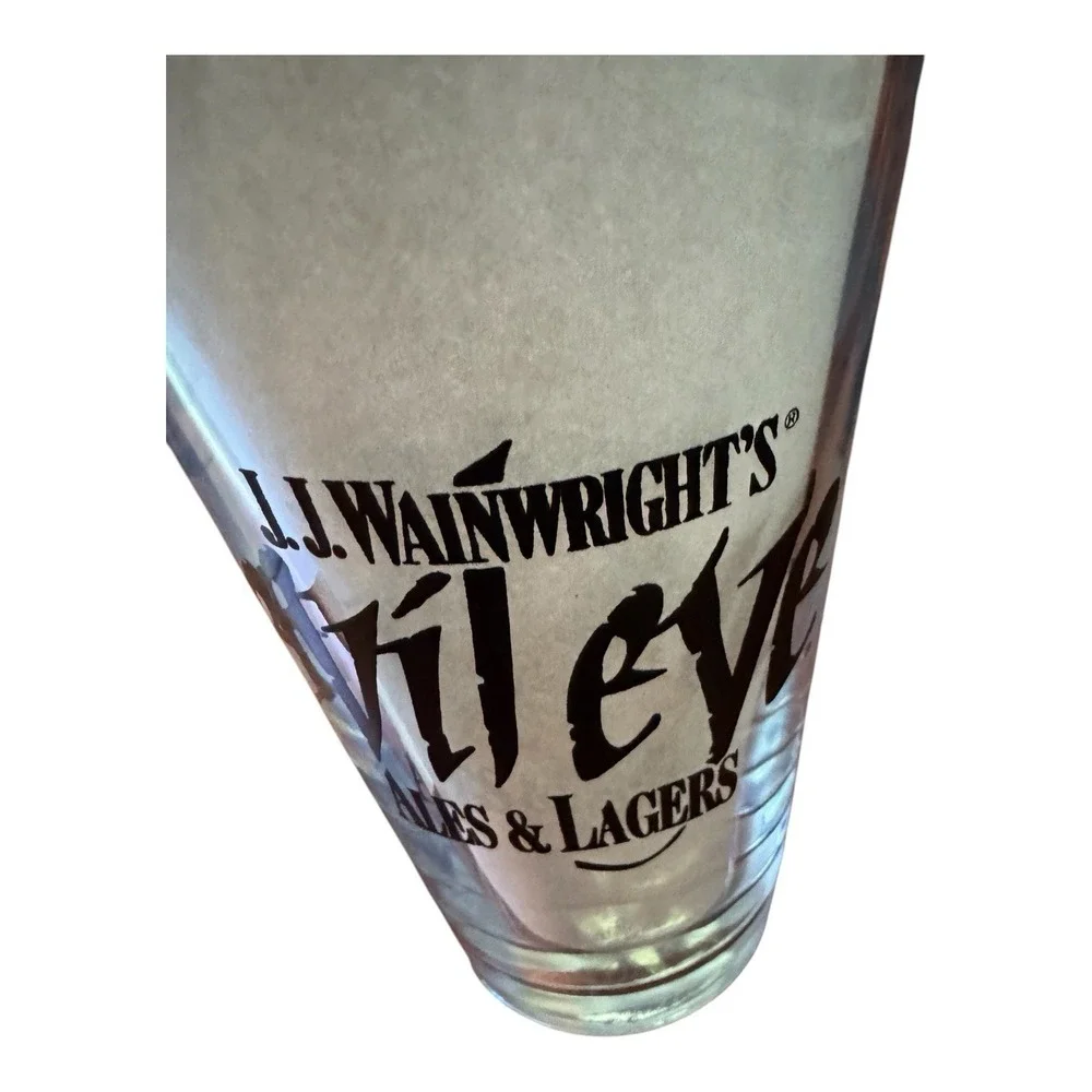 JJ Wainwrights Evil Eye Ales & Lagers Beer Pint Glass Vintage Black Logo Barware